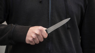 Tânăr în hanorac ține un cuțit în mână