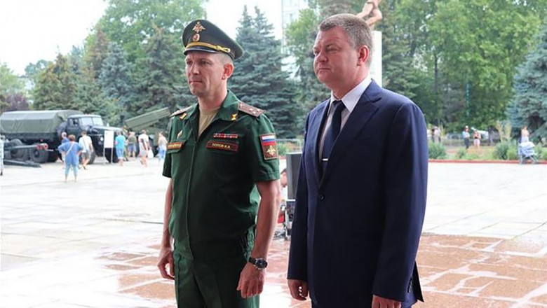 general rus lângă un bărbat îmbrăcat în costum
