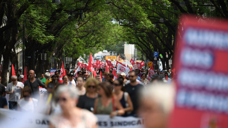 grup de oameni cu steaguri și pancarde pe o strada din Lisabona
