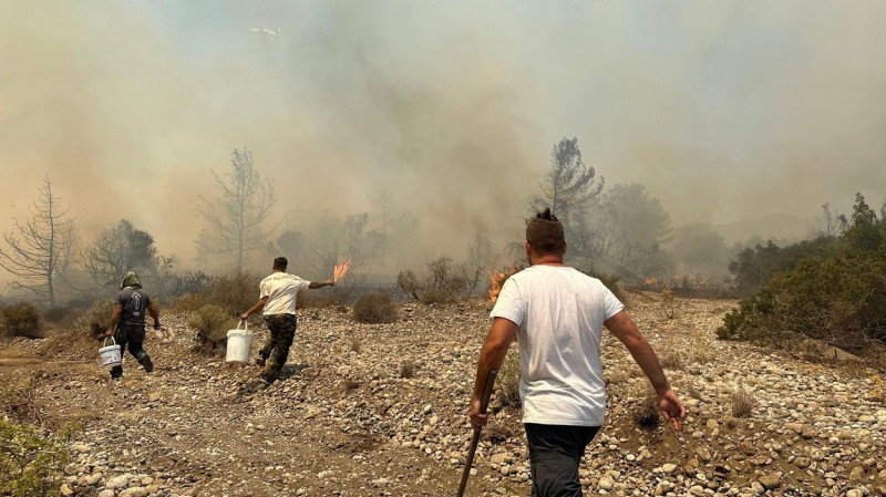 Residents help to extinguish a fire spreading in the central part of the Greek island of Rhodes, on July 25, 2023. (CTK Photo/Pavel Nemecek)