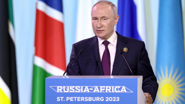 Vladimir Putin la un pupitru inscripționat cu numele summit-ului Rusia-Africa