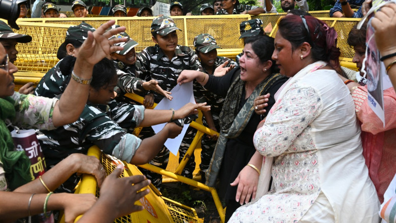 Femei care se confruntă cu polițiști peste baricade