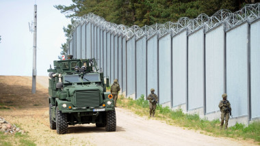 militari si vehicul militar patruleaza langa gardul de la granita polonia belarus