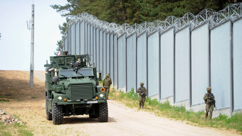 militari si vehicul militar patruleaza langa gardul de la granita polonia belarus