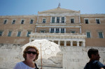 Heat wave in Athens. Tourist protected from the sun with an umbrella in front of Greek Parliament. Syntagma Sq, Athens, Greece.