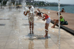 Thessaloniki, Greece, 21st July 2015. Tourists cool off in a fountain in Thessaloniki, northern Greece. A mini heatwave hit Greece on Tuesday with temperatures expected to climb up 40 degrees Celsius in some parts of Greece. The meteorologists are expec