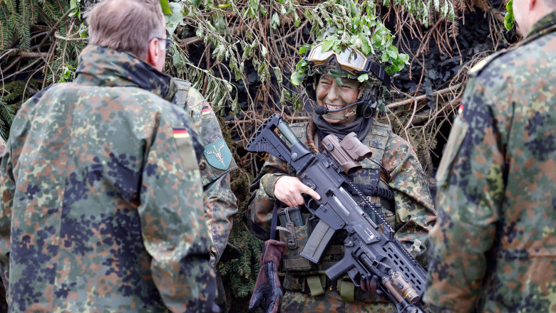 doi bărbați și o femeie îmbrăcați în haine militare, în Germania