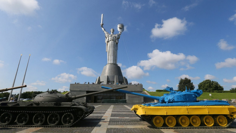 Workers remove the Soviet coat of arms from the shield of the Motherland Monument in Kyiv