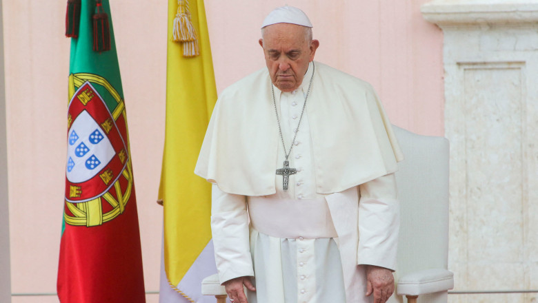 papa francisc lângă steagul portugaliei cu capul plecat