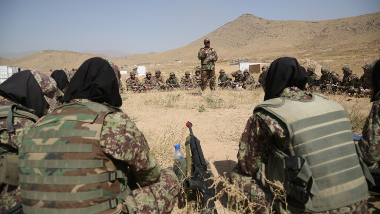 soldați din Afganistan, bărbați și femei stau in cerc și un militar este în centru, le vorbește