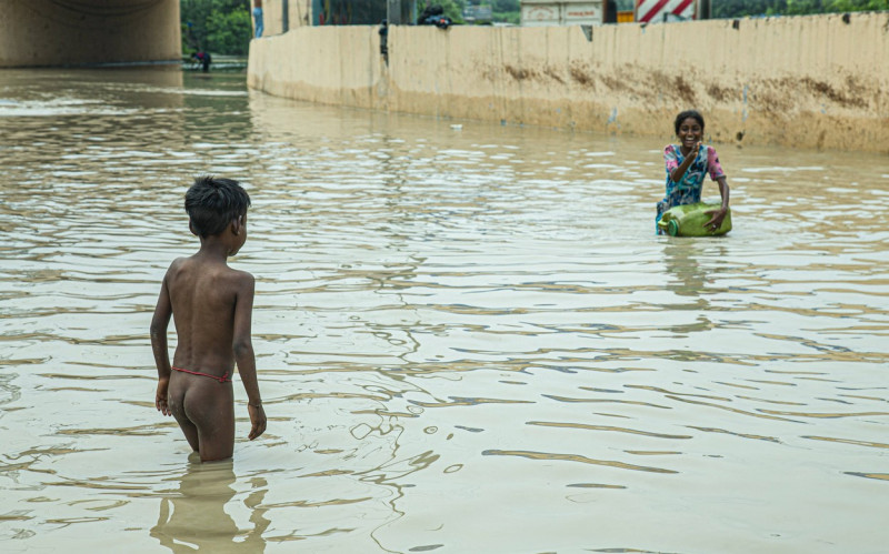 Flood in New Delhi, India Fun Moment: Amid the challenging floodwaters of New Delhi, India, a young girl s laughter reso