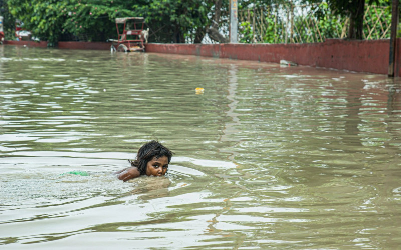 Flood in New Delhi, India Embracing the Moment: A heartwarming scene unfolds as a young girl finds joy in the midst of a