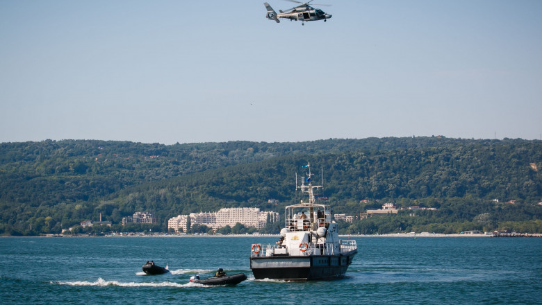 un elicopter și bărci și o navă din marina bulgară pe Marea Neagră, se vede și tărmul bulgăresc
