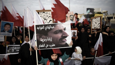 protest în bahrain, o fetită tine o pancarta cu imagine unui activist pentru drepturile omului Abdulhadi al-Khawaja