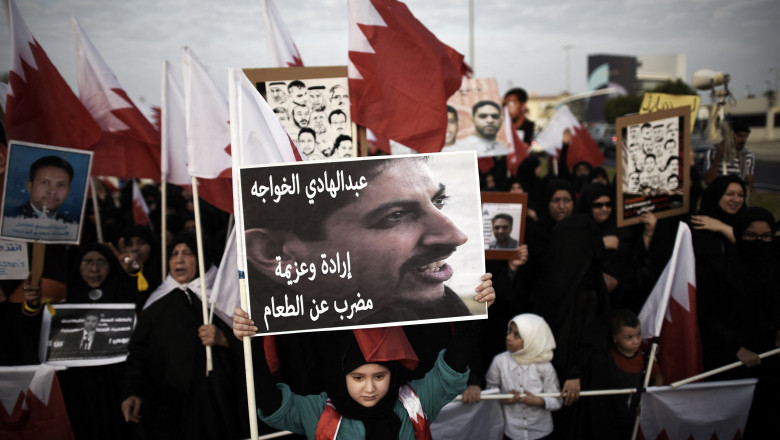 protest în bahrain, o fetită tine o pancarta cu imagine unui activist pentru drepturile omului Abdulhadi al-Khawaja