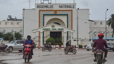 Motocicliști merg pe lângă clădirea Adunării Naționale din Niger