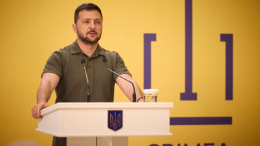 Volodimi Zelenski vorbește de la un pupitru decorat cu stema Ucrainei