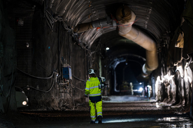 tunel întunecat cu un bărbat în costum de protecție verde