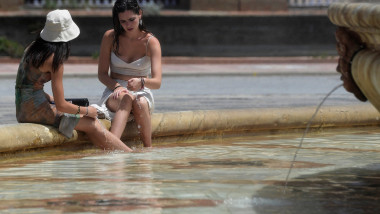 Femei își răcoresc picioarele într-o fântână, în Spania, în timpul valurilor de căldură extremă din vara lui 2023