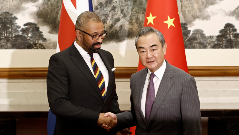 British Foreign Secretary James Cleverly (L) and Chinese Foreign Minister Wang Yi shake hands
