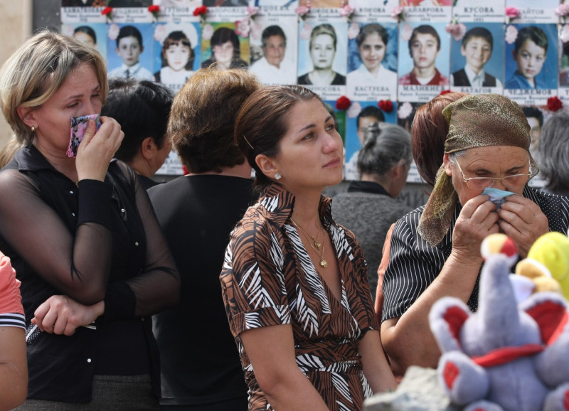 ITAR-TASS 78: NORTH OSSETIA, RUSSIA. SEPTEMBER 3. Mourners look at the photographs of young victims in the for