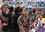 ITAR-TASS 78: NORTH OSSETIA, RUSSIA. SEPTEMBER 3. Mourners look at the photographs of young victims in the for