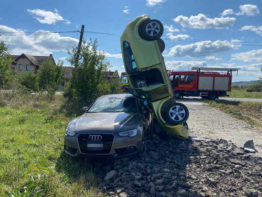 FOTO Accident spectaculos în Bistriţa-Năsăud: O șoferiță s-a răsturnat cu maşina, care a rămas proptită de un alt autoturism