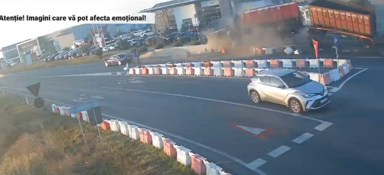 Momentul în care un TIR intră cu viteză într-un sens giratoriu, lovește două mașini și se răstoarnă. Imagini de pe camerele video
