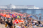 Sunbathers and swimmers on Brighton beach East Sussex, UK.