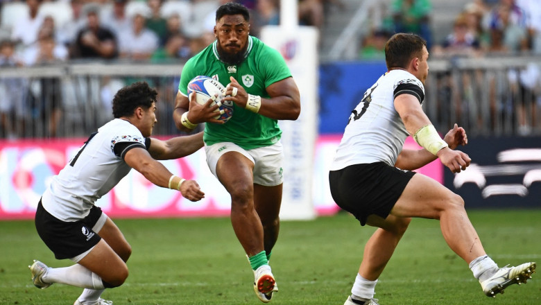 Ireland's centre Bundee Aki (C) is tackled by Romania's scrum half Alin Conache (L) as he runs with the ball during the France 2023 Rugby World Cup