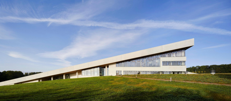 Side elevation with wedge-like shape of building. Moesgaard Museum, Aarhus, Denmark. Architect: Henning Larsen, 2015.
