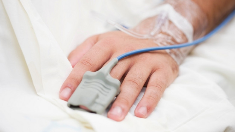 mana unui pacient pe un pat alb de spital
