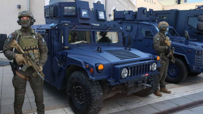 Polițiști din Kosovo înarmați, lângă un vehicul Humvee