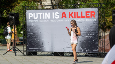 Peaceful protest supporting Ukraine against ongoing war, repressions and call for free with a banner against Putin and a girl looking at the phone