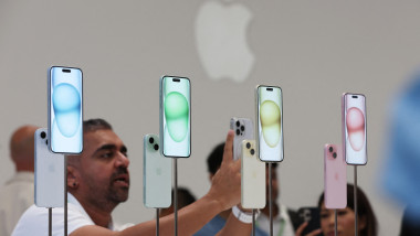 un bărbat fotografiază telefoane iPhone 15 la lansare