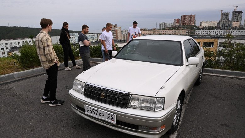 Bărbați inspectează o mașină cu numere rusești