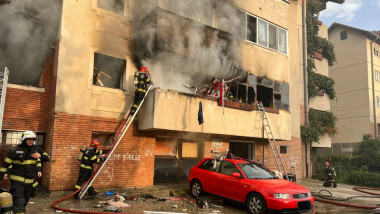 pompieri pe scara intra pe balcon intr-un apartament din care iese fum gros