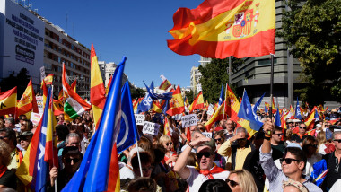 oameni protestează cu steaguri și pancarte la Madrid