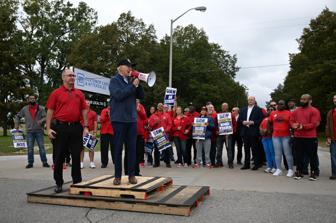 Joe Biden vorbește la un megafon la protestul muncitorilor din Michigan