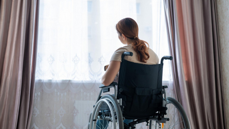 Caucasian woman in a wheelchair at the window.