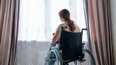 Caucasian woman in a wheelchair at the window.