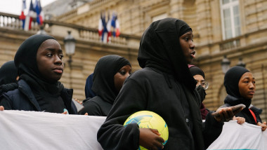 fete cu hijab, una ține o minge în mână, la un protest în Franța