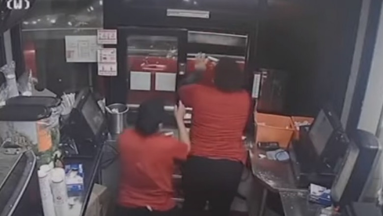 Imaginile de pe camera de supraveghere a unui restaurant fast-food arată momentul în care o angajată amenință cu arma un client