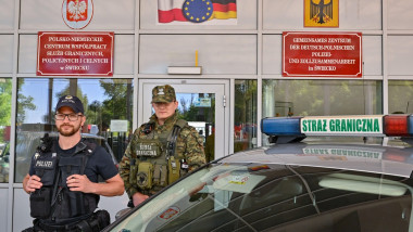 Polițist și militar cu o mașină autospecială în fața graniței polono-germane