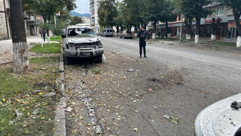 Om în mijlocul drumului, lângă o mașină grav avariată