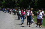 femei merg în coadă pe un drum