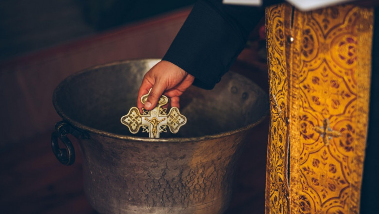 preot ortodox cu o cruce in mana