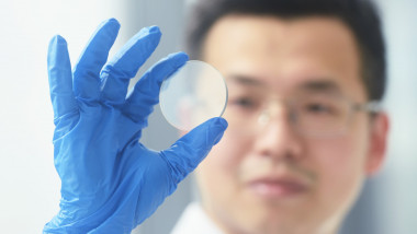 cercetător chinez cu un disc semiconductor într-un centru de cercetare