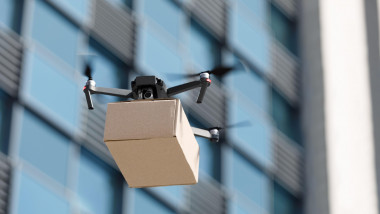 Drone flying through the air with a delivery box package