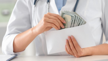 femeie doctor numara bani plic mita spaga